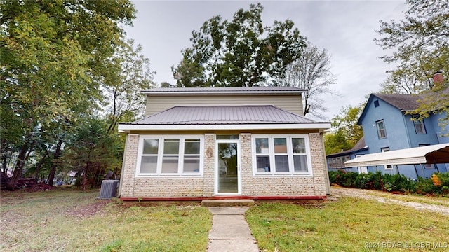 bungalow with central air condition unit and a front yard