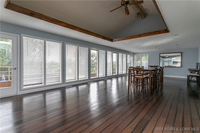 unfurnished dining area featuring vaulted ceiling with beams, dark hardwood / wood-style floors, and ceiling fan