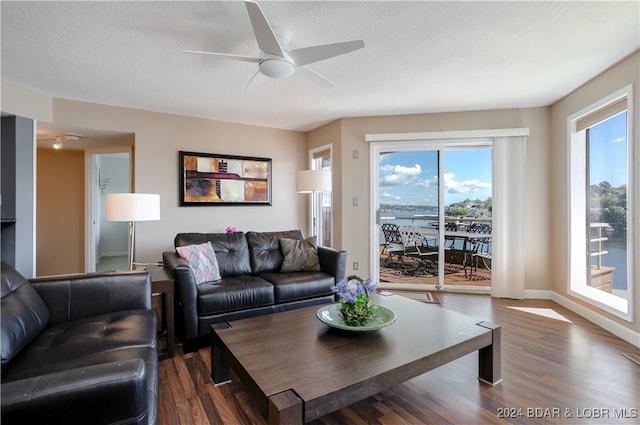 living room featuring a textured ceiling, dark hardwood / wood-style floors, and ceiling fan