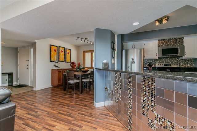 kitchen featuring hardwood / wood-style floors, appliances with stainless steel finishes, a textured ceiling, and white cabinets