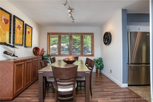 dining room with dark wood-type flooring and a textured ceiling