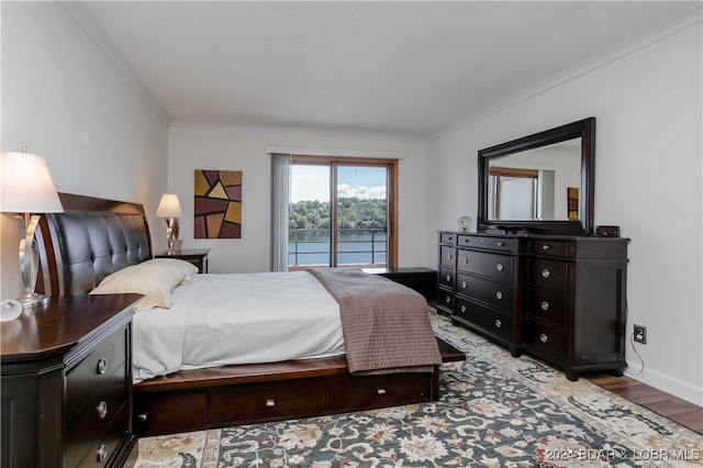 bedroom featuring access to outside, a water view, ornamental molding, and light wood-type flooring