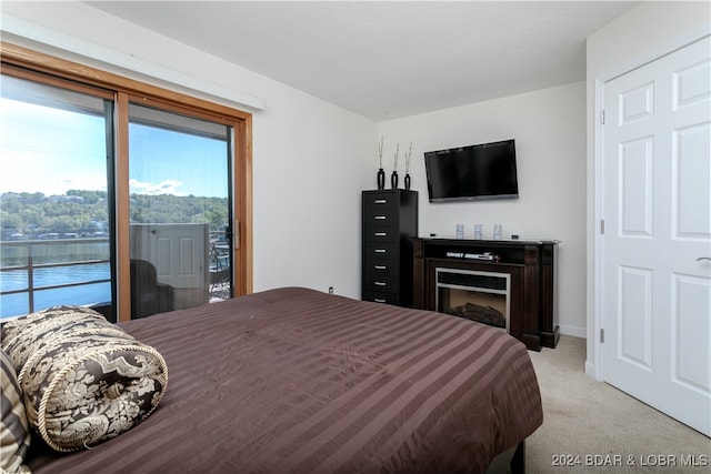 bedroom featuring light carpet and access to outside