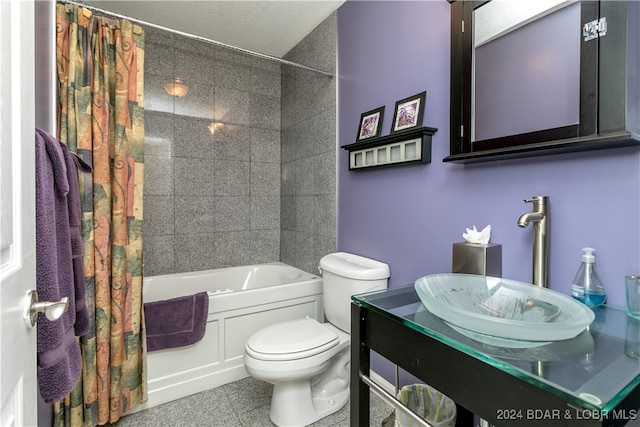 full bathroom featuring a textured ceiling, toilet, shower / bath combo with shower curtain, vanity, and tile patterned flooring