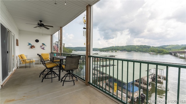 balcony with a water view and ceiling fan