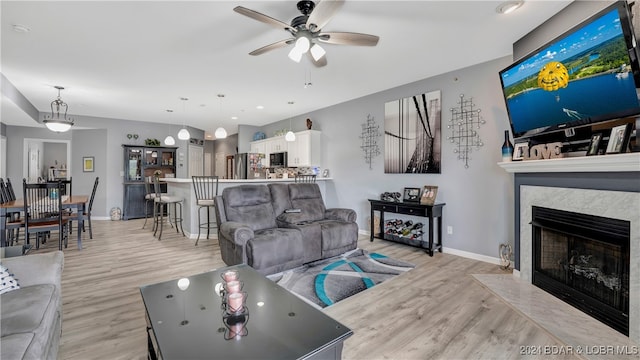 living room featuring ceiling fan and light hardwood / wood-style floors