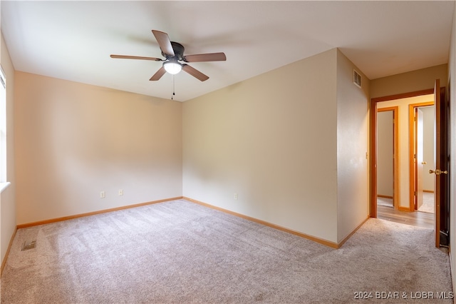 spare room featuring ceiling fan and light carpet