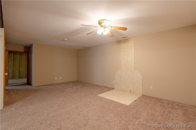 carpeted empty room with ceiling fan and a textured ceiling