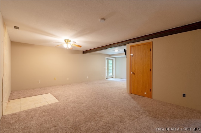 unfurnished room with beam ceiling, light carpet, ceiling fan, and a textured ceiling