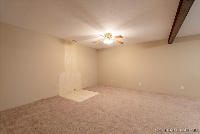 carpeted empty room with beamed ceiling, ceiling fan, and a textured ceiling