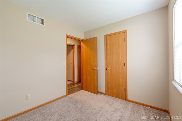 unfurnished bedroom featuring light colored carpet