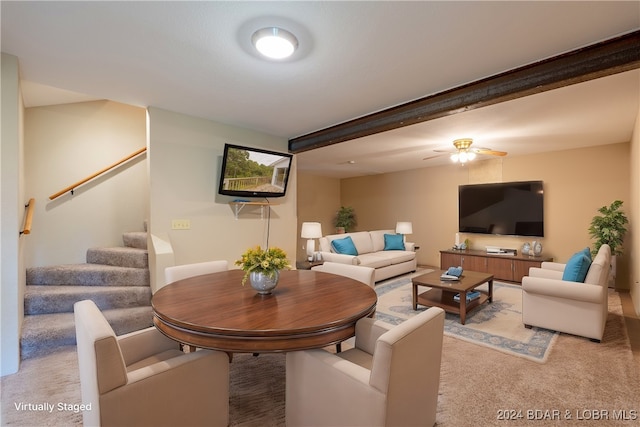 living room featuring beamed ceiling, light colored carpet, and ceiling fan