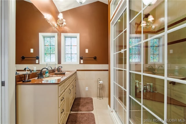 bathroom featuring a notable chandelier, tile walls, vanity, and tile patterned floors