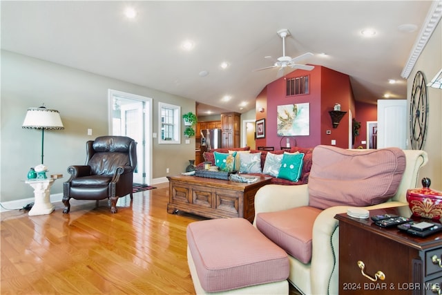 living room with light wood-type flooring, vaulted ceiling, and ceiling fan