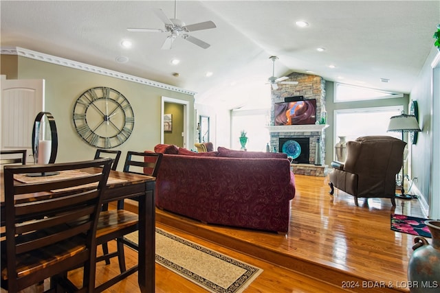 living room with ceiling fan, lofted ceiling, a fireplace, and wood-type flooring