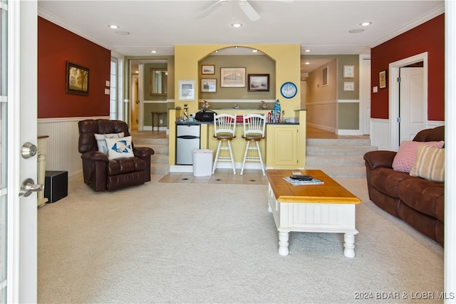 carpeted living room featuring ornamental molding and ceiling fan