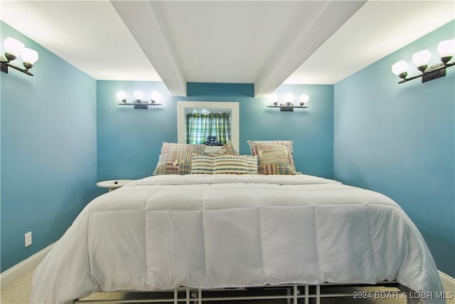 carpeted bedroom featuring beam ceiling