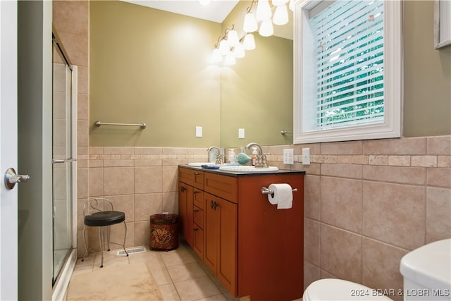 bathroom featuring tile walls, an enclosed shower, vanity, and toilet