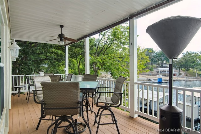 deck with ceiling fan and a water view