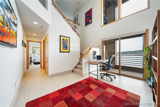 office space featuring hardwood / wood-style flooring and a towering ceiling