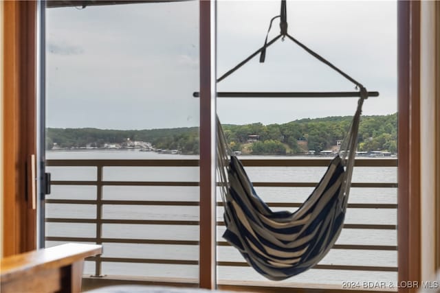 interior space with a balcony and a water view