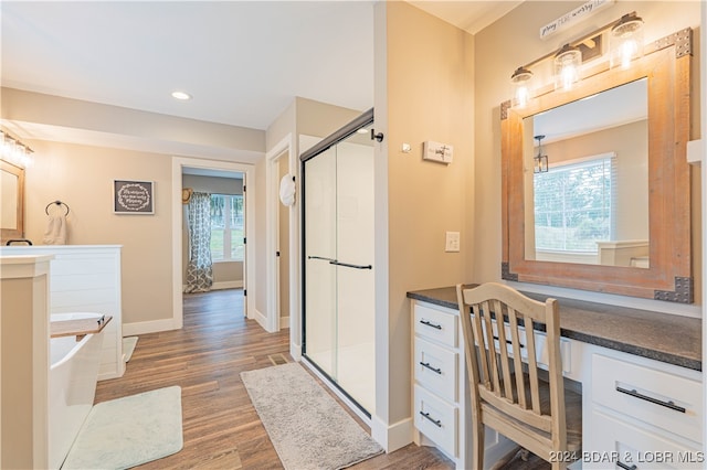 bathroom featuring a healthy amount of sunlight, hardwood / wood-style floors, and independent shower and bath