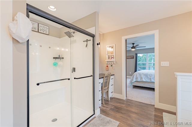 bathroom with ceiling fan, hardwood / wood-style flooring, and a shower with shower door