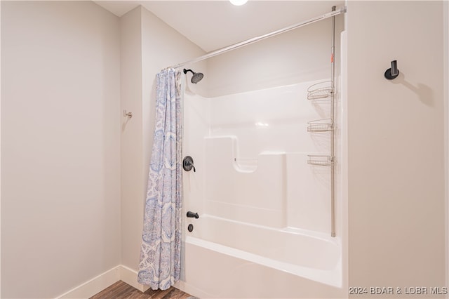 bathroom featuring wood-type flooring and shower / bathtub combination with curtain