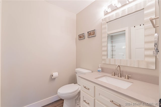 bathroom featuring a shower, hardwood / wood-style floors, vanity, and toilet