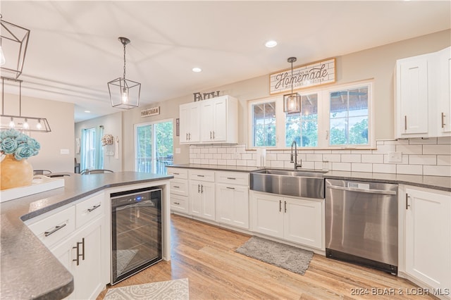 kitchen with pendant lighting, beverage cooler, sink, and dishwasher