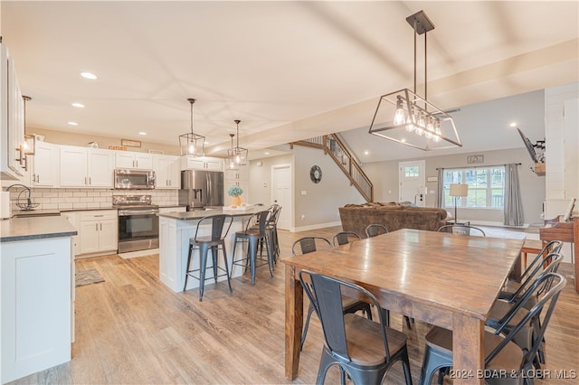 dining space with light wood-type flooring and sink