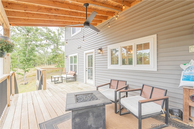 deck with ceiling fan and an outdoor fire pit