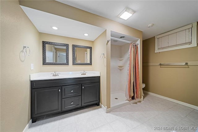 bathroom with baseboards, a sink, double vanity, and a stall shower