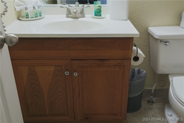 bathroom featuring tile patterned flooring, vanity, and toilet