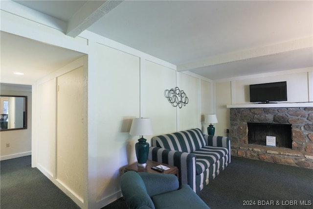 living room featuring a stone fireplace, beam ceiling, and dark carpet