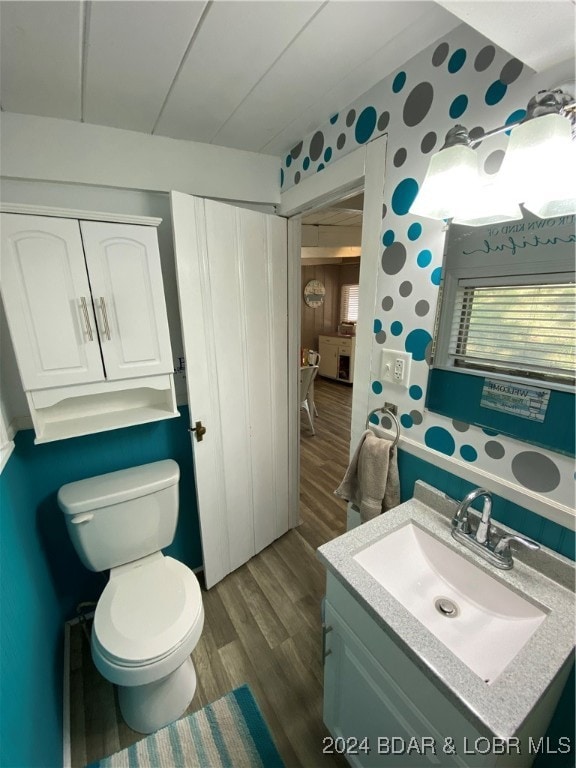 bathroom featuring vanity, hardwood / wood-style floors, and toilet