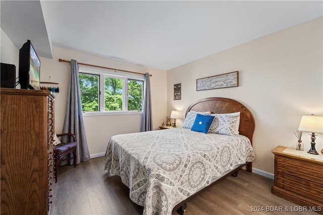 bedroom with dark wood-type flooring