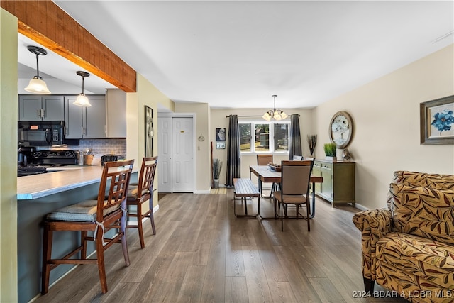 dining space with a notable chandelier and dark hardwood / wood-style floors