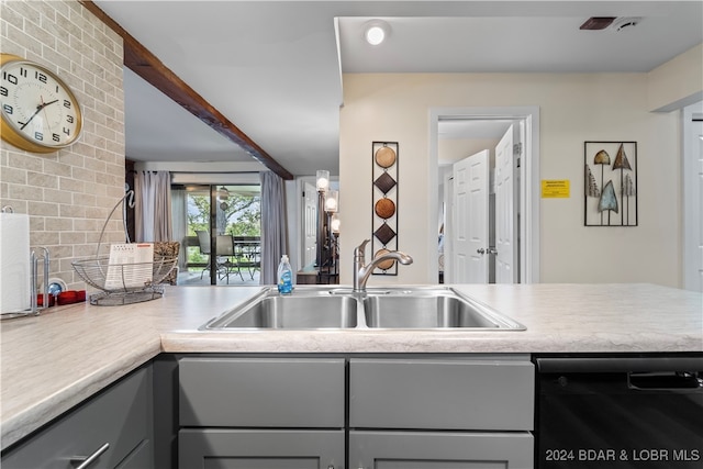 kitchen with black dishwasher, backsplash, sink, and gray cabinetry