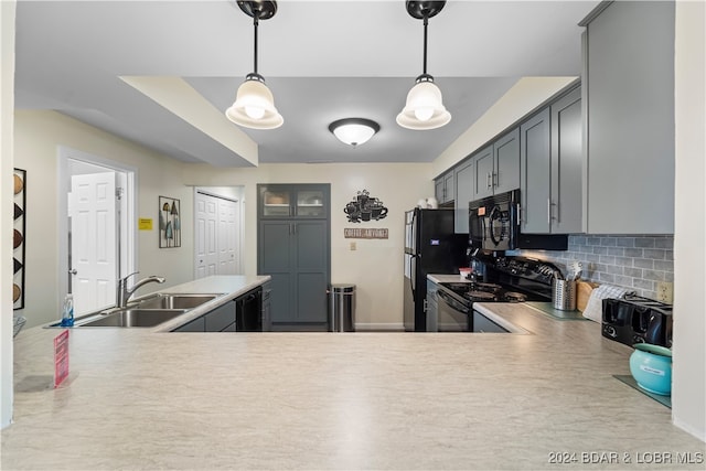 kitchen with hanging light fixtures, sink, tasteful backsplash, black appliances, and gray cabinets