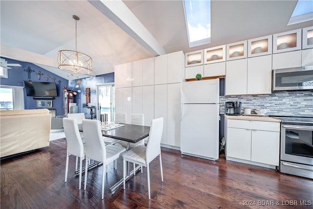 kitchen featuring hanging light fixtures, lofted ceiling with skylight, white cabinetry, and stainless steel appliances