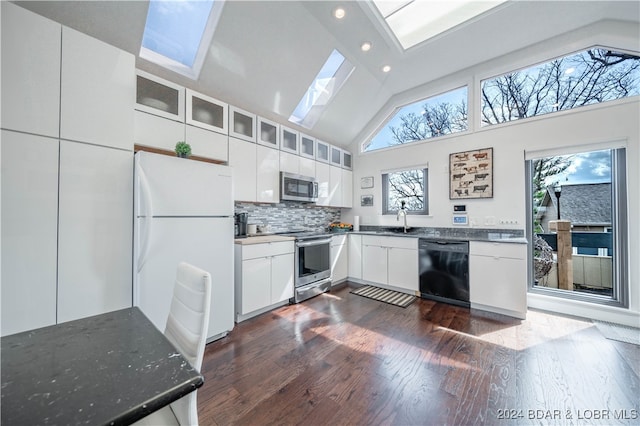 kitchen with appliances with stainless steel finishes, a wealth of natural light, a skylight, and white cabinets