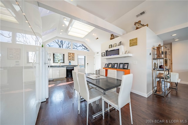 dining space featuring sink, beam ceiling, dark wood-type flooring, and high vaulted ceiling