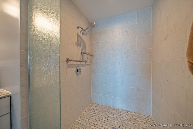 bathroom featuring tiled shower and vanity