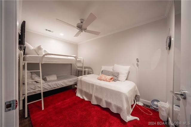 carpeted bedroom featuring ceiling fan and crown molding