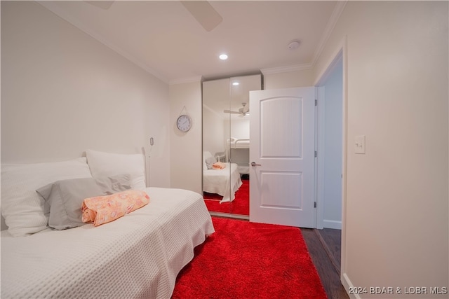 bedroom featuring ornamental molding, a closet, ceiling fan, and dark hardwood / wood-style floors