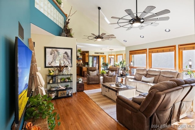 living room with ceiling fan, light wood-type flooring, and high vaulted ceiling