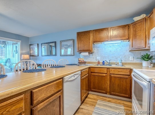 kitchen featuring decorative backsplash, light wood-type flooring, white appliances, and sink