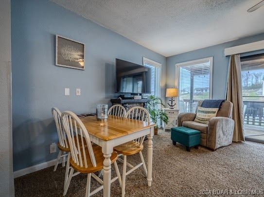 dining area with a textured ceiling and carpet flooring