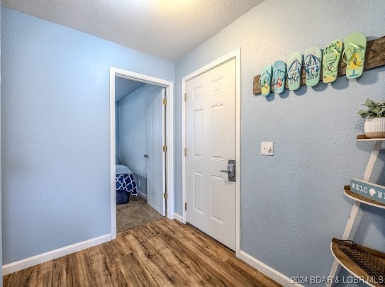 hallway featuring a textured ceiling and hardwood / wood-style flooring